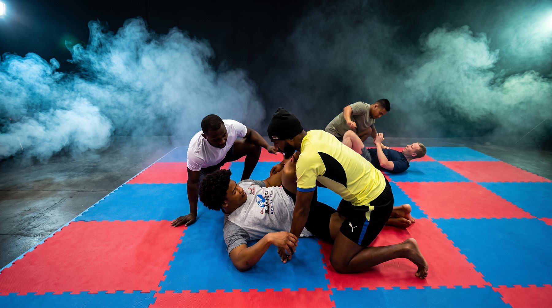 Worsteltraining: sporters oefenen grondtechnieken op de mat